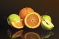 Apples and oranges fruits with drops and splashes of water on a black background Royalty Free Stock Photo