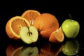 Apples  and oranges fruits with drops and splashes of water on a black background Royalty Free Stock Photo