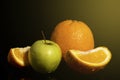 Apples and oranges fruits with drops and splashes of water on a black background Royalty Free Stock Photo