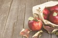 Apples in paper package on a dark wooden background. Copy space. Royalty Free Stock Photo