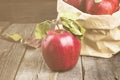Apples in paper package on a dark wooden background. Toned Royalty Free Stock Photo