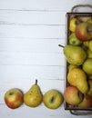 Apples and pears in a wooden box on white wooden table flat lay. Concept of harvesting Royalty Free Stock Photo