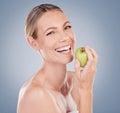 Apples are the perfect snack. Studio portrait of an attractive young woman posing with an apple against a grey Royalty Free Stock Photo