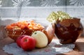 Apples, plate with raspberries and cracked clay pot with flower in sunlight Royalty Free Stock Photo