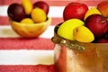 Apples, prunes and apricots in old copper pot and wooden bowl on the background