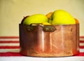 Apples, prunes and apricots in old copper pot and wooden bowl on the background