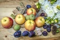 Apples,prunes,figs and green nuts with a bouquet of white dahlias