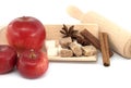 Apples, sugar, cinnamon sticks and anise stars near rolling pin