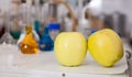 Apples on table on background of lab equipment Royalty Free Stock Photo
