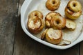 Apples topped nuts honey cinnamon baking dish wooden table side Royalty Free Stock Photo