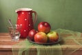 Apples and water glass on wooden table over rustic background. Artistic retro still life