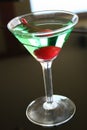 appletini cocktail with red cheries inside, vodka, pineapple juice, liqueur in classic martini cocktail glass Royalty Free Stock Photo