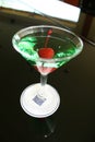 appletini cocktail with red cheries inside, vodka, pineapple juice, liqueur in classic martini cocktail glass Royalty Free Stock Photo
