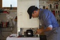 Appliance service technician in his workshop repairing a faulty refrigerator. Technician at work Royalty Free Stock Photo
