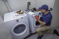 Appliance technician working on a front load washing machine in a laundry room Royalty Free Stock Photo
