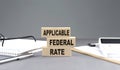 APPLICABLE FEDERAL RATE text on wooden block with notebook,chart and calculator, grey background Royalty Free Stock Photo