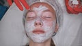 Application of a cream mask on the face of a girl with problem skin in the salon. Royalty Free Stock Photo