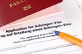Application for Schengen visa, passport and pen.