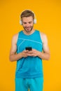 Application for trainings with online couch. Athletic man listen music smartphone. Workout playlist. Sport and fitness