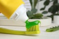 Applying aloe toothpaste on toothbrush at white table, closeup Royalty Free Stock Photo