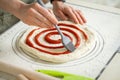 Applying berry jam to dessert roll dough with a kitchen brush