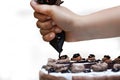 Applying chocolate cream with cone top of delicious vanilla cake Royalty Free Stock Photo