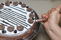 Applying chocolate cream on vaniila cake with cake nozzel Royalty Free Stock Photo