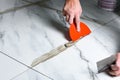 Applying fugue on ceramic tiles with a spatula. Royalty Free Stock Photo