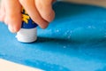 Applying glue stick to the blue paper Royalty Free Stock Photo