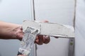 Applying glue to a white decorative gypsum brick. Brick laying on the wall, close-up