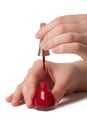 Applying red nail polish on female fingers