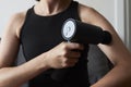 Applying therapeutic percussive massager gun at home Royalty Free Stock Photo