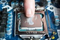 Applying thermal paste with finger during CPU Intel i5 installation on motherboard Royalty Free Stock Photo