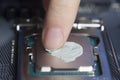 Applying thermal paste with finger in CPU on motherboard Royalty Free Stock Photo