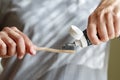 Applying toothpaste on a bamboo tooth brush. Hands squeezing tube with a toothpaste Royalty Free Stock Photo