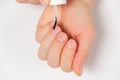 Applying a transparent varnish, degreaser to the nails close-up on a white background. Royalty Free Stock Photo