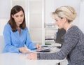 Appointment at a specialist for finance: female customer and adv Royalty Free Stock Photo