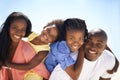 Appreciating each other - Family fun times. Two parents giving their children a piggyback while on the beach. Royalty Free Stock Photo