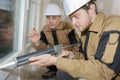 apprentice being advised how to apply caulk to window