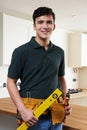 Apprentice Carpenter Installing Luxury Fitted Kitchen Royalty Free Stock Photo