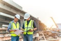 Apprentice and civil engineer inspecting and working outdoors road construction site with blueprint and tablet. Civil Engineer Royalty Free Stock Photo