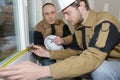 Apprentice construction man using tape measurer at site