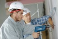 apprentice drilling holes at construction site Royalty Free Stock Photo