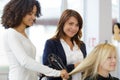 apprentice drying clients hair using blowdry Royalty Free Stock Photo