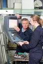 Apprentice And Engineer Using Computer Controlled Cutting Machin Royalty Free Stock Photo