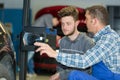 Apprentice learning about equipment for testing cars Royalty Free Stock Photo