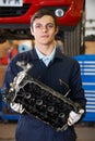 Apprentice Machanic Holding Engine Block In Garage Royalty Free Stock Photo
