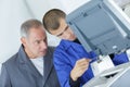 Apprentice and master repairing broken printer Royalty Free Stock Photo
