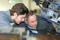 Apprentice mechanic in auto shop working on car engine Royalty Free Stock Photo