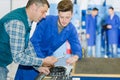 Apprentice mechanic in auto shop working on car engine Royalty Free Stock Photo